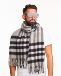 A model styled in a charcoal and red cashmere scarf, representing the brand's global appeal.
