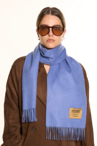 A folded light blue cashmere scarf in a luxury signature box