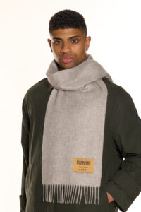 A grey cashmere scarf neatly folded in an elegant gift box.