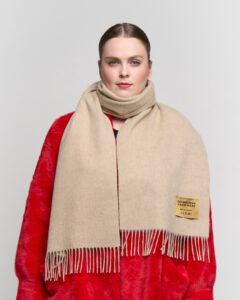 A close-up of a Thomson Red scarf, its vibrant hue symbolising the fiery creative energy of the performing arts.